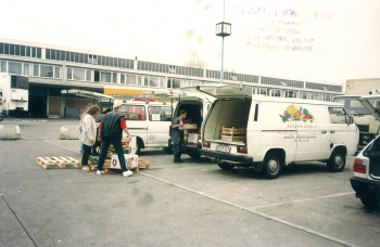 Bild aus den Gründungszeiten der Berliner Tafel,Helfende, die einen Transporter mit Lebensmittelspenden beladen