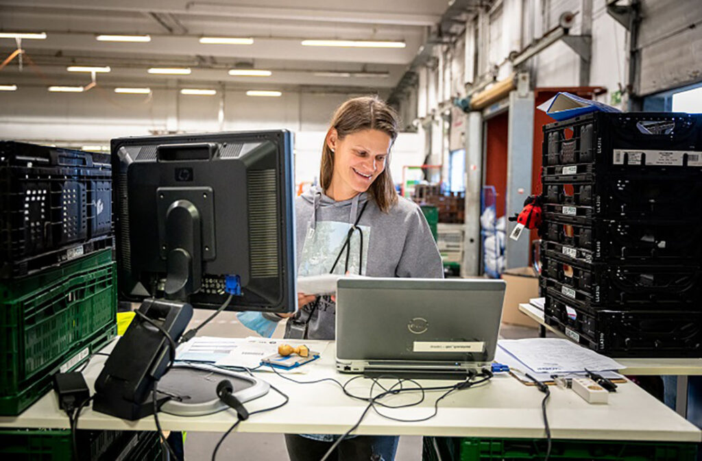 Eine Tafel-Helferin trägt am Laptop Daten ein.