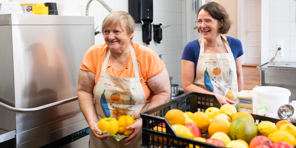 Zwei Tafel-Helferinnen waschen in einer Küche Gemüse.