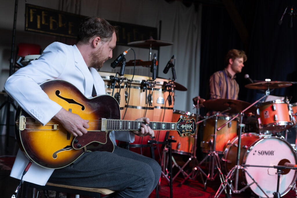 Die Band spielt Musik auf der Bühne. 