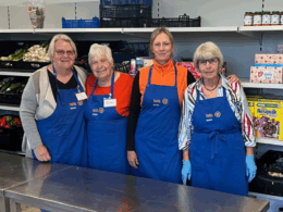 4 Tafel-Helferinnen posieren in neuen Schürzen, die die Tafel Dieburg dank der Lidl-Pfandspende kaufen konnte.