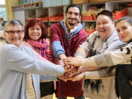 5 Tafel-Aktive posieren mit zusammengelegten Händen für Vielfalt im Engagement