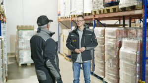 Alex Brunner spricht im Lager der Tafel Bayern mit einem Lageristen.