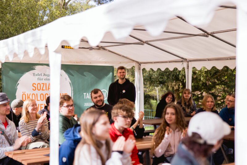 Beim CAMP der Tafel Jugend sitzen Engagierte zusammen im Freien.