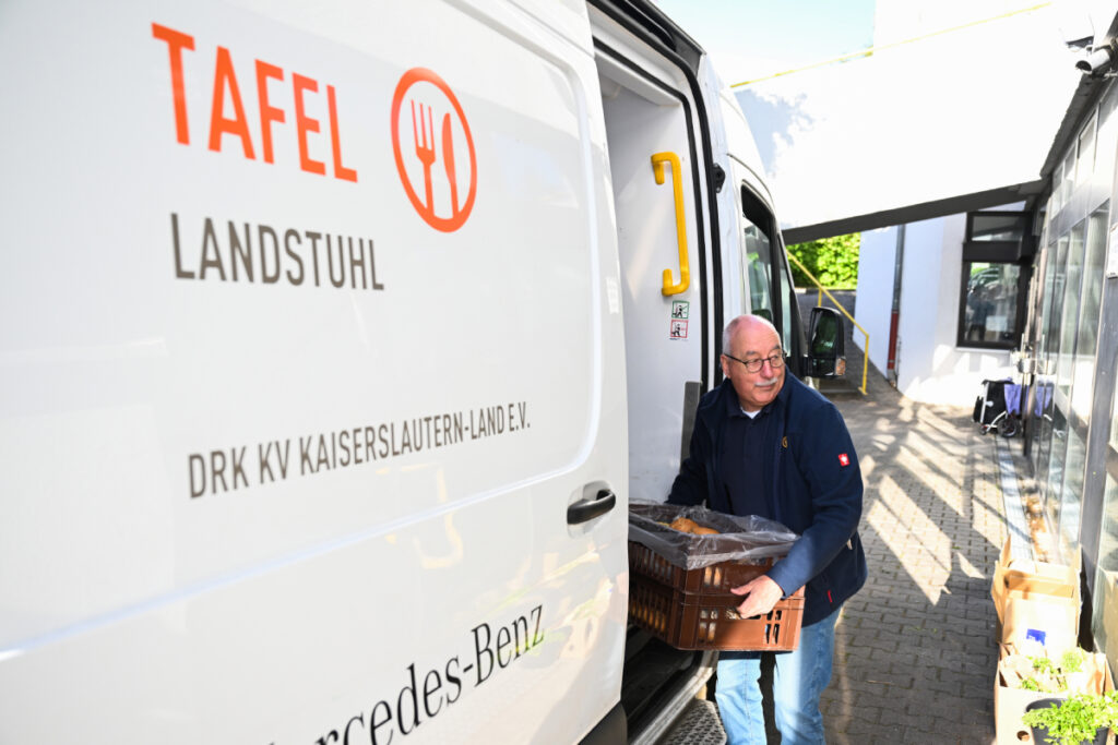 Ein Tafel-Helfer lädt Saisonware bei den Tafeln aus einem Fahrzeug aus.
