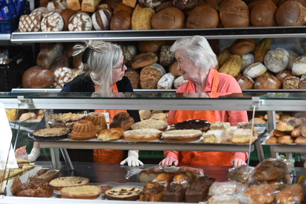 2 Tafel-Helferinnen unterhalten sich hinter der Bäckereitheke