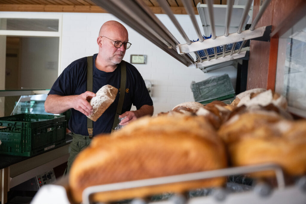 Ein Tafel-Helfer legt Brot in die Auslage.