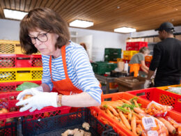 Lebensmittelretter:innen bei den Tafeln sortieren Gemüse.