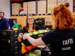 Die Tafel Jugend im Einsatz überreicht Kisten voller Lebensmittel.