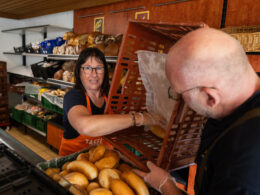 2 Tafel-Helfer:innen sortieren Brötchen nach dem Motto "Teilen, um zusammenzuhalten".